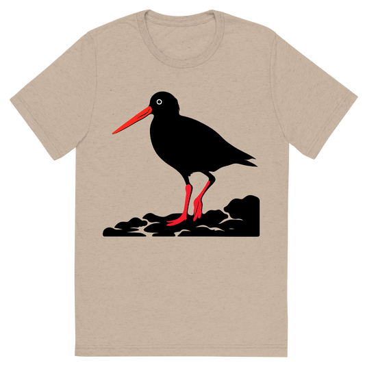 Front view of a Premium Tri-Blend Crew Neck T-Shirt in Tan showing 'A high-contrast silhouette with minimal accent color, striking graphic of a stylized silhouette of an american oystercatcher standing on a rocky shore, long orange bill and pink legs highlighted with color, high contrast silhouette, transparent background, centered composition, optimized for dtg printing'