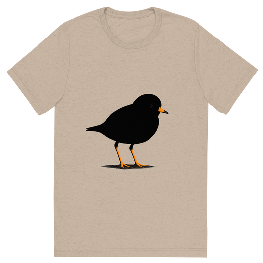 Front view of a Premium Tri-Blend Crew Neck T-Shirt in Tan showing 'A high-contrast silhouette with minimal accent color, delicate graphic of a small silhouette of a piping plover standing on the sand with orange legs and beak highlighted, transparent background, optimized for dtg printing'