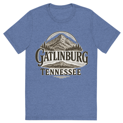 Front view of a Premium Tri-Blend Crew Neck T-Shirt in Blue showing 'A typographic, nostalgic graphic of a typographic illustration of the words 'gatlinburg, tennessee' with a vintage line art drawing of ober mountain'