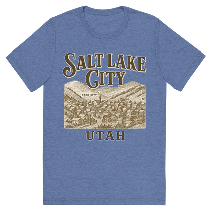 Front view of a Premium Tri-Blend Crew Neck T-Shirt in Blue showing 'A typographic, nostalgic graphic of a typographic illustration of the words 'salt lake city, utah' with a vintage line art drawing of park city'