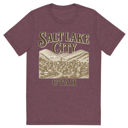 Front view of a Premium Tri-Blend Crew Neck T-Shirt in Maroon showing 'A typographic, nostalgic graphic of a typographic illustration of the words 'salt lake city, utah' with a vintage line art drawing of park city'