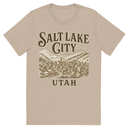 Front view of a Premium Tri-Blend Crew Neck T-Shirt in Tan showing 'A typographic, nostalgic graphic of a typographic illustration of the words 'salt lake city, utah' with a vintage line art drawing of park city'