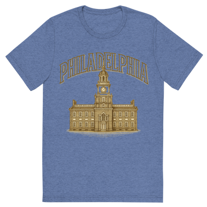 Front view of a Premium Tri-Blend Crew Neck T-Shirt in Blue showing 'A typographic, nostalgic graphic of a typographic illustration of the words 'philadelphia' with a vintage line art drawing of independence hall'