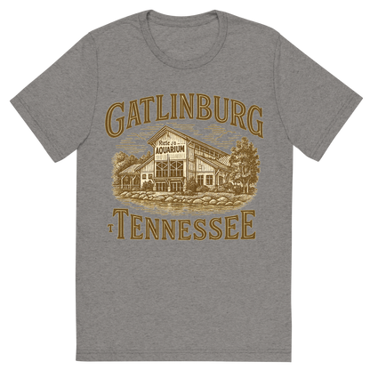 Front view of a Premium Tri-Blend Crew Neck T-Shirt in Grey showing 'A typographic, nostalgic graphic of a typographic illustration of the words 'gatlinburg, tennessee' with a vintage line art drawing of ripley’s aquarium'
