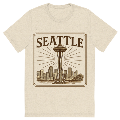 Front view of a Premium Tri-Blend Crew Neck T-Shirt in Oatmeal showing 'A typographic, nostalgic graphic of a typographic illustration of the words 'seattle' with a vintage line art drawing of the space needle'