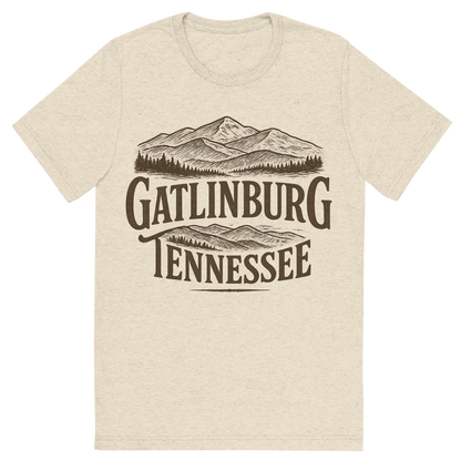 Front view of a Premium Tri-Blend Crew Neck T-Shirt in Oatmeal showing 'A typographic, nostalgic graphic of a typographic illustration of the words 'gatlinburg, tennessee' with a vintage line art drawing of the great smoky mountains'