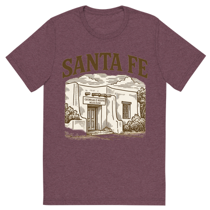 Front view of a Premium Tri-Blend Crew Neck T-Shirt in Maroon showing 'A typographic, nostalgic graphic of a typographic illustration of the words 'santa fe' with a vintage line art drawing of the georgia o’keeffe museum'