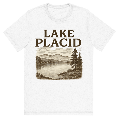 Front view of a Premium Tri-Blend Crew Neck T-Shirt in Solid White showing 'A typographic, nostalgic graphic of a typographic illustration of the words 'lake placid' with a vintage line art drawing of mirror lake'