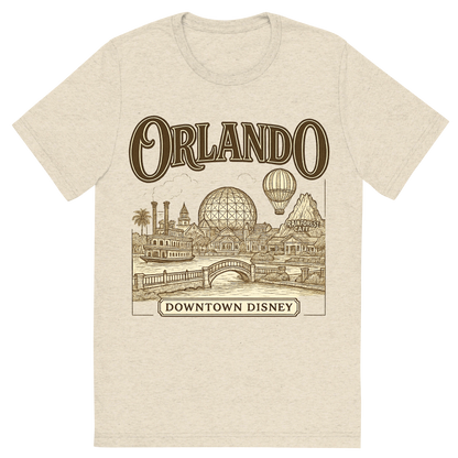Front view of a Premium Tri-Blend Crew Neck T-Shirt in Oatmeal showing 'A typographic, nostalgic graphic of a typographic illustration of the words 'orlando' with a vintage line art drawing of downtown disney'