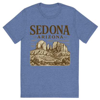Front view of a Premium Tri-Blend Crew Neck T-Shirt in Blue showing 'A typographic, nostalgic graphic of a typographic illustration of the words 'sedona, arizona' with a vintage line art drawing of the red rock formations'