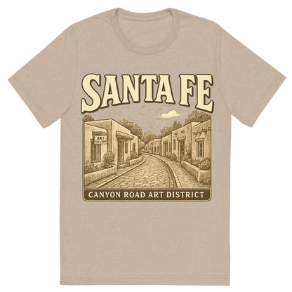 Front view of a Premium Tri-Blend Crew Neck T-Shirt in Tan showing 'A typographic, nostalgic graphic of a typographic illustration of the words 'santa fe' with a vintage line art drawing of the canyon road art district'