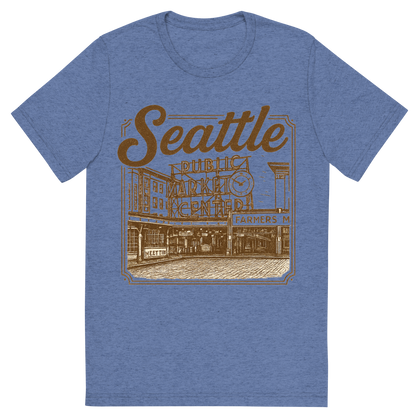 Front view of a Premium Tri-Blend Crew Neck T-Shirt in Blue showing 'A typographic, nostalgic graphic of a typographic illustration of the words 'seattle' with a vintage line art drawing of the pike place market'