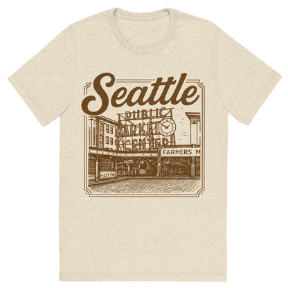 Front view of a Premium Tri-Blend Crew Neck T-Shirt in Oatmeal showing 'A typographic, nostalgic graphic of a typographic illustration of the words 'seattle' with a vintage line art drawing of the pike place market'