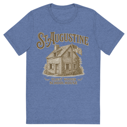 Front view of a Premium Tri-Blend Crew Neck T-Shirt in Blue showing 'A typographic, nostalgic graphic of a typographic illustration of the words 'st. augustine' with a vintage line art drawing of the oldest wooden schoolhouse'