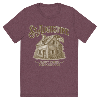 Front view of a Premium Tri-Blend Crew Neck T-Shirt in Maroon showing 'A typographic, nostalgic graphic of a typographic illustration of the words 'st. augustine' with a vintage line art drawing of the oldest wooden schoolhouse'