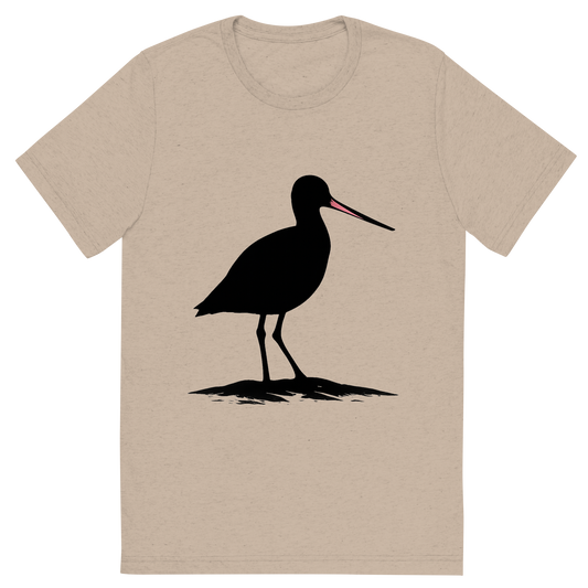Front view of a Premium Tri-Blend Crew Neck T-Shirt in Tan showing 'A high-contrast silhouette with minimal accent color, distinct graphic of a silhouette of a marbled godwit in profile, long slightly upturned bill accented in pink, standing on sand flats, transparent background, optimized for dtg printing'