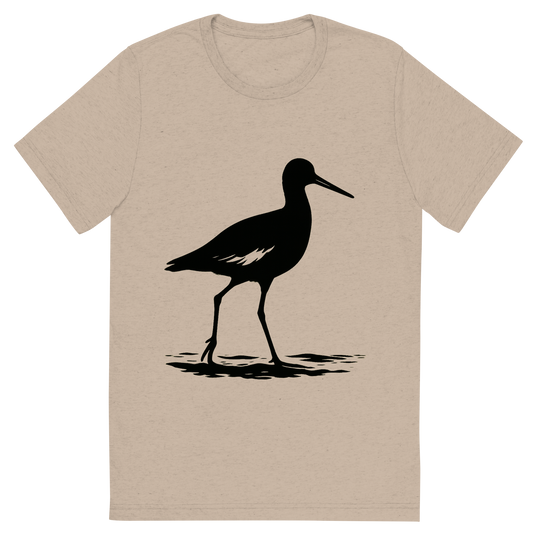 Front view of a Premium Tri-Blend Crew Neck T-Shirt in Tan showing 'A high-contrast silhouette with minimal accent color, steady graphic of a bold silhouette of a willet standing tall on the shoreline, long legs and bill, with wing patch hints when in motion, transparent background, optimized for dtg printing'