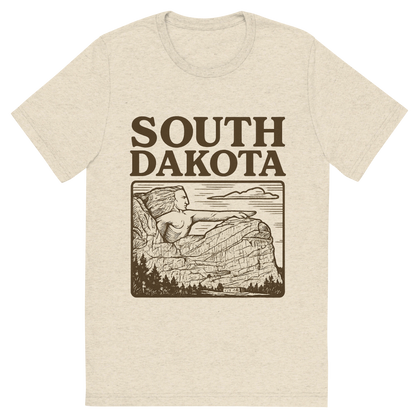 Front view of a Premium Tri-Blend Crew Neck T-Shirt in Oatmeal showing 'A typographic, nostalgic graphic of a typographic illustration of the words 'south dakota' with a vintage line art drawing of the crazy horse memorial'