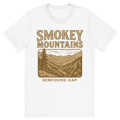 Front view of a Premium Tri-Blend Crew Neck T-Shirt in Solid White showing 'A typographic, nostalgic graphic of a typographic illustration of the words 'smokey mountains' with a vintage line art drawing of the newfound gap'