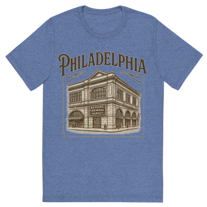 Front view of a Premium Tri-Blend Crew Neck T-Shirt in Blue showing 'A typographic, nostalgic graphic of a typographic illustration of the words 'philadelphia' with a vintage line art drawing of the reading terminal market'