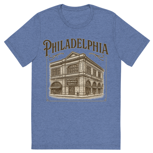 Front view of a Premium Tri-Blend Crew Neck T-Shirt in Blue showing 'A typographic, nostalgic graphic of a typographic illustration of the words 'philadelphia' with a vintage line art drawing of the reading terminal market'