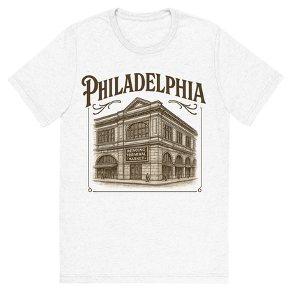 Front view of a Premium Tri-Blend Crew Neck T-Shirt in Solid White showing 'A typographic, nostalgic graphic of a typographic illustration of the words 'philadelphia' with a vintage line art drawing of the reading terminal market'