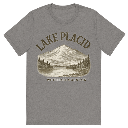 Front view of a Premium Tri-Blend Crew Neck T-Shirt in Grey showing 'A typographic, nostalgic graphic of a typographic illustration of the words 'lake placid' with a vintage line art drawing of whiteface mountain'