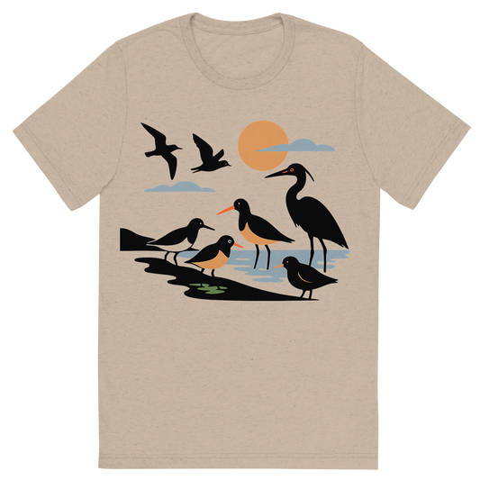 Front view of a Premium Tri-Blend Crew Neck T-Shirt in Tan showing 'A high-contrast silhouette with minimal accent color, natural graphic of a symbolic illustration of diverse shore birds arranged along a minimalist coastline scene—some wading, some flying, in high-contrast silhouettes with minimal pops of color, square layout, transparent background, not for direct printing'