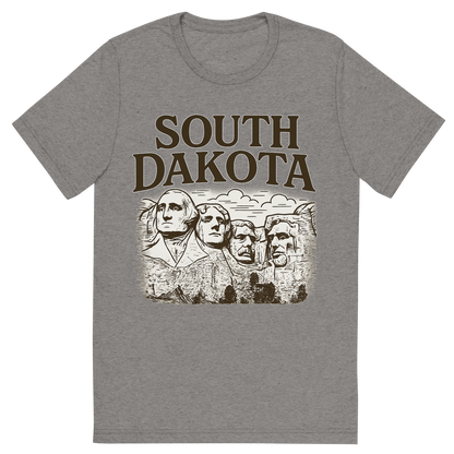 Front view of a Premium Tri-Blend Crew Neck T-Shirt in Grey showing 'A typographic, nostalgic graphic of a typographic illustration of the words 'south dakota' with a vintage line art drawing of the presidential sculptures'