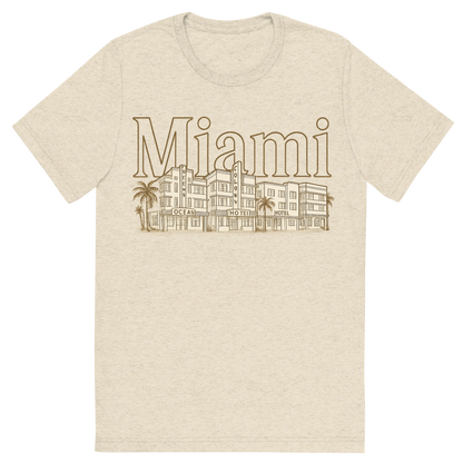 Front view of a Premium Tri-Blend Crew Neck T-Shirt in Oatmeal showing 'A typographic, nostalgic graphic of a typographic illustration of the words 'miami' with a vintage line art drawing of the art deco historic district'