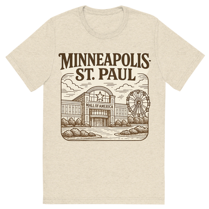 Front view of a Premium Tri-Blend Crew Neck T-Shirt in Oatmeal showing 'A typographic, nostalgic graphic of a typographic illustration of the words 'minneapolis-st. paul' with a vintage line art drawing of the mall of america'