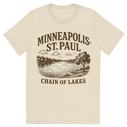 Front view of a Premium Tri-Blend Crew Neck T-Shirt in Oatmeal showing 'A typographic, nostalgic graphic of a typographic illustration of the words 'minneapolis-st. paul' with a vintage line art drawing of the chain of lakes'
