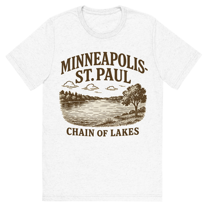 Front view of a Premium Tri-Blend Crew Neck T-Shirt in Solid White showing 'A typographic, nostalgic graphic of a typographic illustration of the words 'minneapolis-st. paul' with a vintage line art drawing of the chain of lakes'
