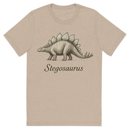 Front view of a Premium Tri-Blend Crew Neck T-Shirt in Tan showing 'A flat, neutral graphic of a drawing of a stegosaurus with its distinctive plated back and spiked tail. “stegosaurus” is written beneath in elegant script. ink illustration on a white background.'