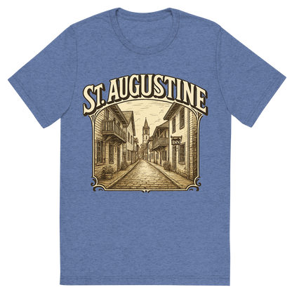 Front view of a Premium Tri-Blend Crew Neck T-Shirt in Blue showing 'A typographic, nostalgic graphic of a typographic illustration of the words 'st. augustine' with a vintage line art drawing of st. george street'