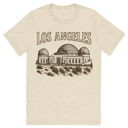 Front view of a Premium Tri-Blend Crew Neck T-Shirt in Oatmeal showing 'A typographic, nostalgic graphic of a typographic illustration of the words 'los angeles' with a vintage line art drawing of the griffith observatory'