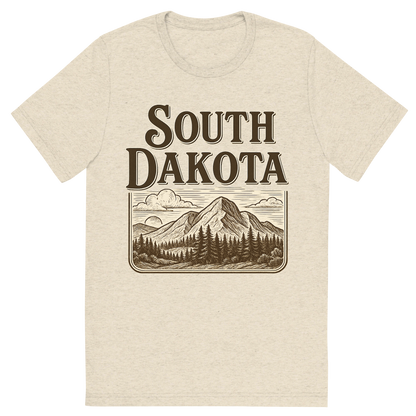 Front view of a Premium Tri-Blend Crew Neck T-Shirt in Oatmeal showing 'A typographic, nostalgic graphic of a typographic illustration of the words 'south dakota' with a vintage line art drawing of the black hills'