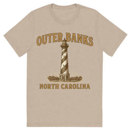 Front view of a Premium Tri-Blend Crew Neck T-Shirt in Tan showing 'A typographic, nostalgic graphic of a typographic illustration of the words 'outer banks, north carolina' with a vintage line art drawing of the cape hatteras lighthouse'