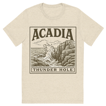 Front view of a Premium Tri-Blend Crew Neck T-Shirt in Oatmeal showing 'A typographic, nostalgic graphic of a typographic illustration of the words 'acadia' with a vintage line art drawing of thunder hole'