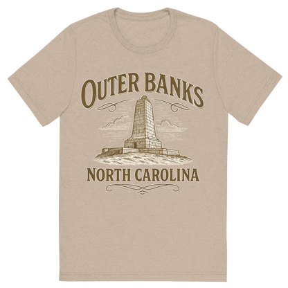 Front view of a Premium Tri-Blend Crew Neck T-Shirt in Tan showing 'A typographic, nostalgic graphic of a typographic illustration of the words 'outer banks, north carolina' with a vintage line art drawing of the wright brothers memorial'