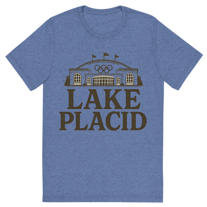 Front view of a Premium Tri-Blend Crew Neck T-Shirt in Blue showing 'A typographic, nostalgic graphic of a typographic illustration of the words 'lake placid' with a vintage line art drawing of the olympic center'