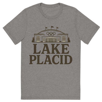 Front view of a Premium Tri-Blend Crew Neck T-Shirt in Grey showing 'A typographic, nostalgic graphic of a typographic illustration of the words 'lake placid' with a vintage line art drawing of the olympic center'